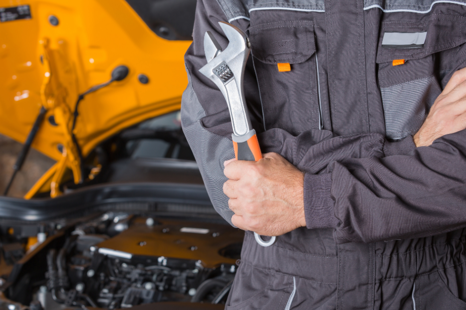 Profesional mecánico con una herramienta para reparar una pieza mecánica del coche