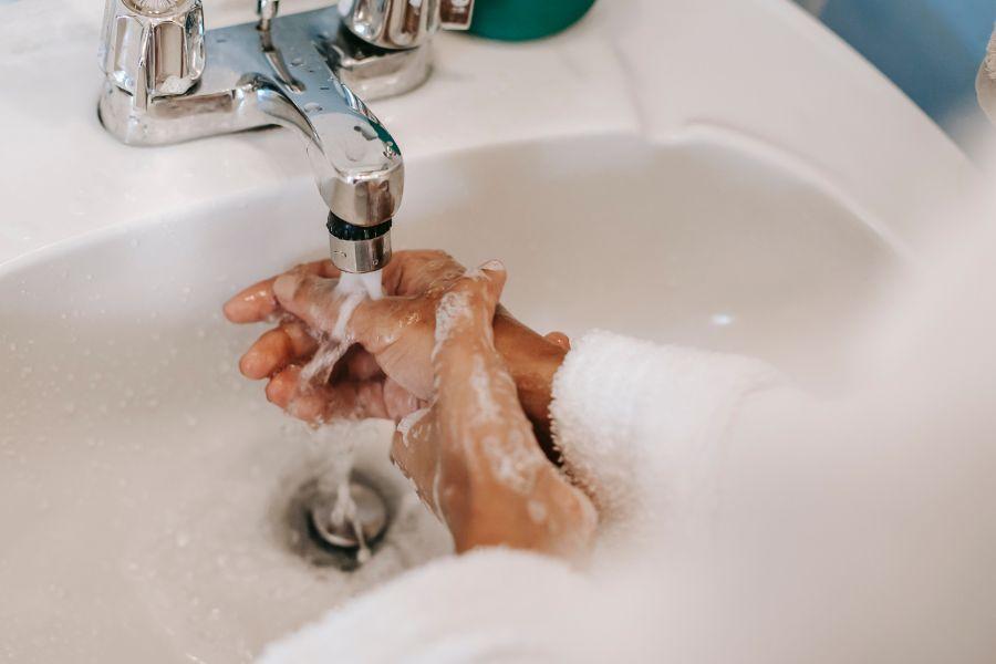 una mujer lavándose las manos con agua y jabón