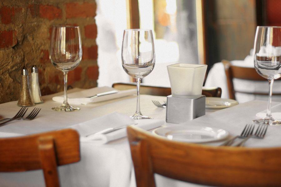 mesa de restaurante preparada con mantel blanco